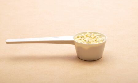Lupin flour in measuring spoon on brown backgroundの写真素材