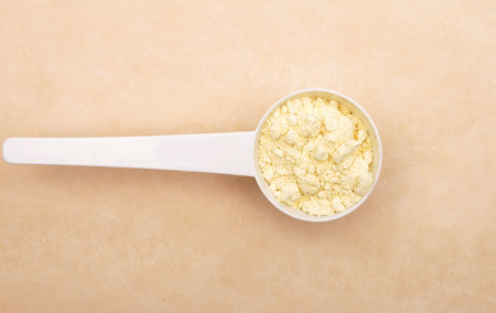 Lupine flour in measuring spoon on brown backgroundの写真素材