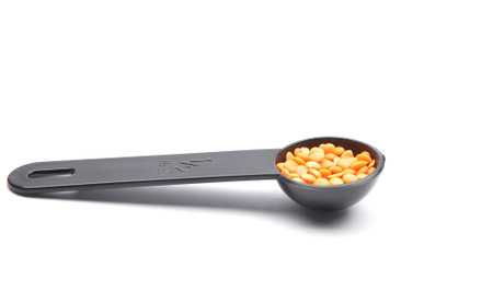 Red lentils on measuring spoon and white backgroundの写真素材