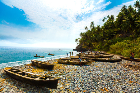 Locals bring their row boats in on the rocky coast of Sao Tome.の写真素材