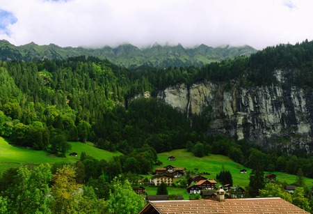 Tourist Town of Lauterbrunnen in Lauterbrunnen Valley (Switzerland) with the View of Wooded Cliffsの写真素材