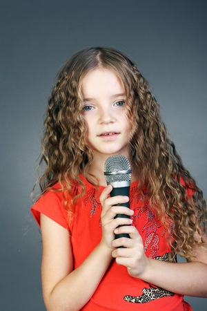 beautiful little girl with the microphone in her handsの写真素材
