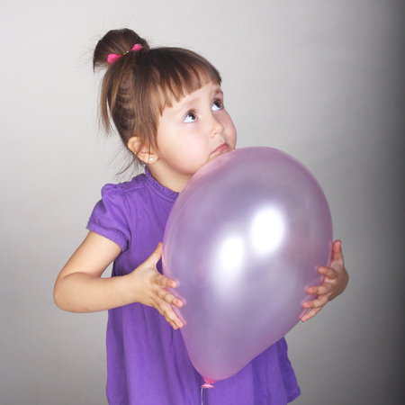 cute little baby with a lilac balloonの写真素材