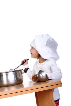 cute little baby dressed as a cook looking upの写真素材