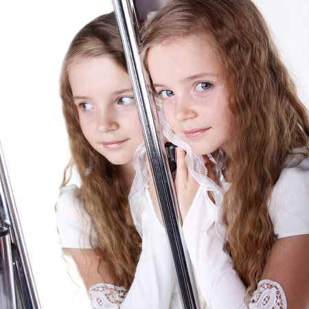 reflection of a beautiful little girl in the mirrorの写真素材