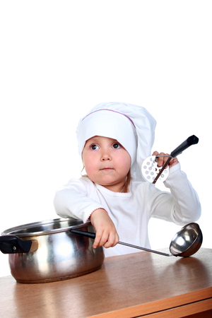 happy cute little baby in a cook cap with a panの写真素材
