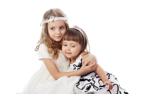 two cute little girls posing sitting in studioの写真素材