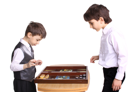 two little boys playing backgammon in studio
