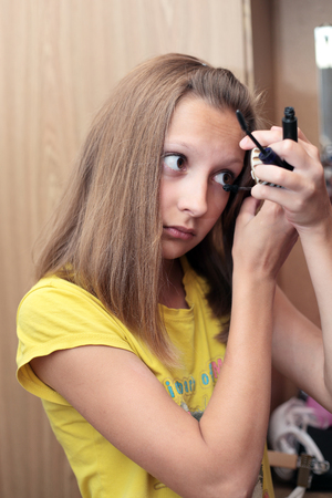 closeup image of the pretty preteen girl applying mascaraの写真素材