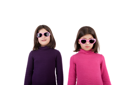 two happy little twin sisters in the sunglassesの写真素材