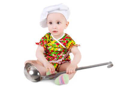 cute sweet little baby in the cook cap and with the big ladleの写真素材