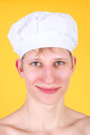 handsome young man in the cooking cap on the yellow backgroundの写真素材
