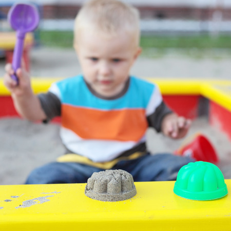 cute little child playing in the sandbox on the playground