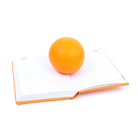 big bright orange on the open diaryの写真素材