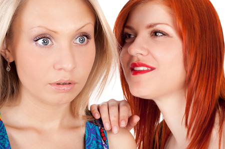 two pretty young girls whisperingの写真素材