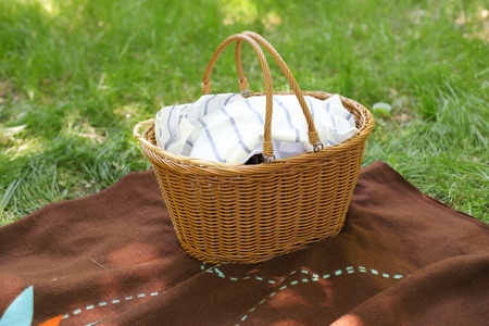 picnic basket on the plaid in the parkの写真素材