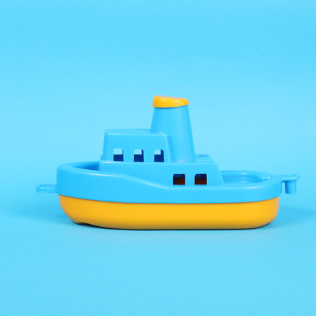 little plastic toy ship on the blue backgroundの写真素材