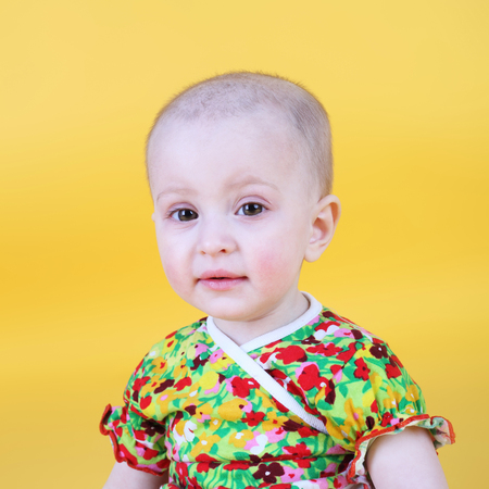 cute sweet little baby on the yellow backgroundの写真素材