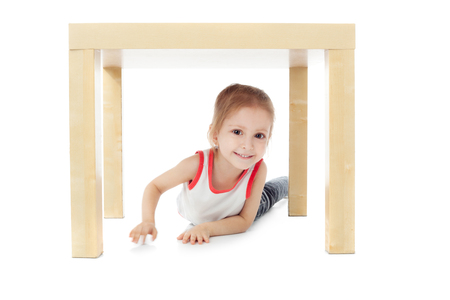 cute little girl playing under the tableの写真素材