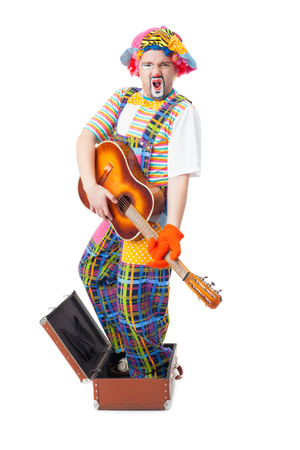 handsome young clown with the guitar and trunkの写真素材