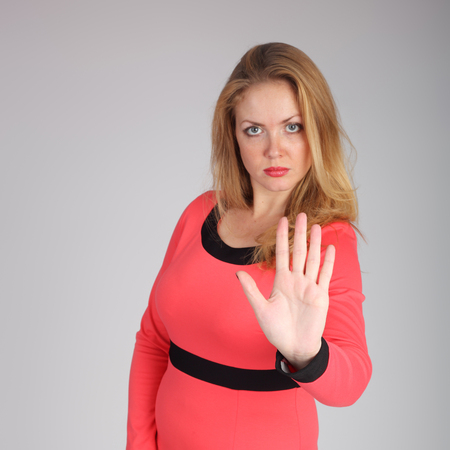 Pretty young woman showing stop signの写真素材