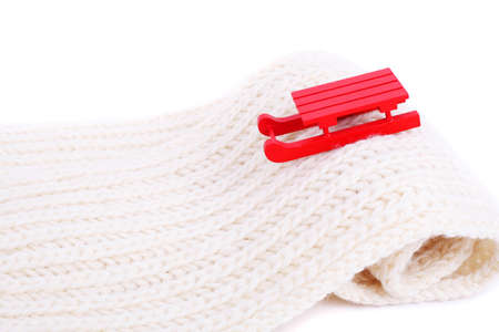 red wooden sledge christmas souvenir on the white mountain made of scarf, side viewの写真素材