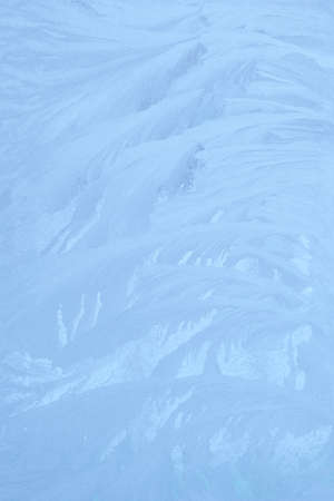 blue winter ice ornament on the glassの写真素材