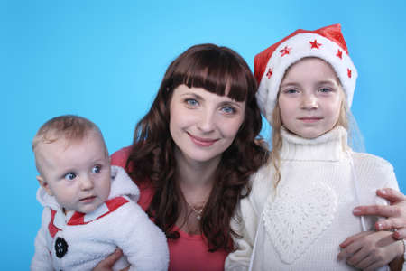 pretty young mother with the cute little children on the blue backgroundの写真素材