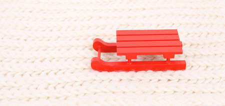 red wooden sledge christmas souvenir on the white scarf mountainの写真素材