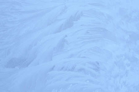 blue winter ice ornament on the glass, background for christmas and new yearの写真素材