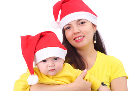 pretty happy young mother with the cute little baby dressed in new year capsの写真素材