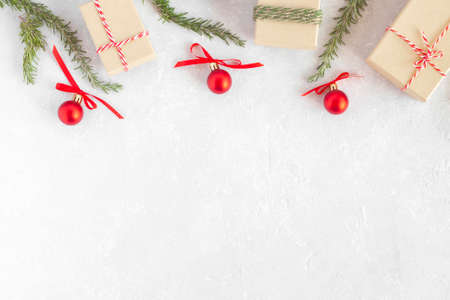 christmas gift boxes, new year tree branches and red decorative balls on light gray background, top view, copy spaceの写真素材