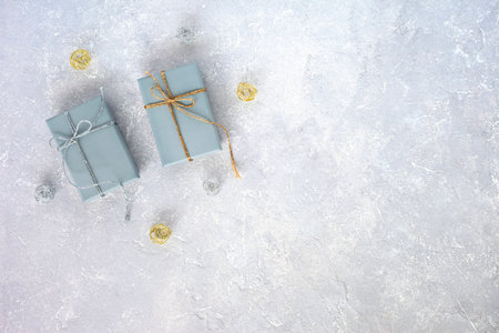 two gray giftboxes decorated silver and golden ribbons on the gray background, holiday concept, christmas, birthday, top view, copy spaceの写真素材