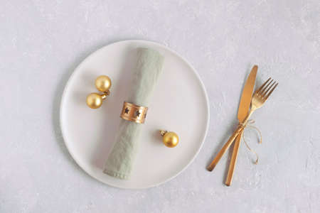 plate and cutlery for new year dinner, top view, golden colors, on gray backgroundの写真素材