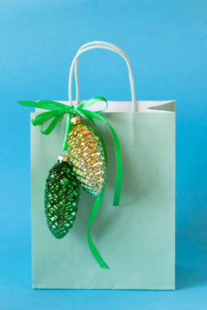 green paper bag decorated with glass cones, blue background, side view, copy spaceの写真素材