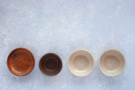 Set of four empty ceramic bowls on greyの写真素材