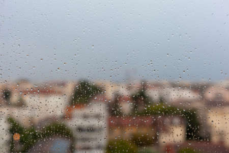 european city view through the rain drops on the window, autumn cityscapeの写真素材
