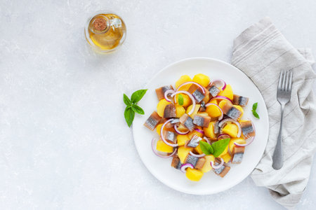 smoked herring, potatoes and red onion salad on a plate, concept of fresh food, side viewの写真素材