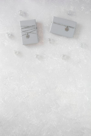 gray Christmas gift boxes decorated with snowflakes on gray background, top view, copy spaceの写真素材