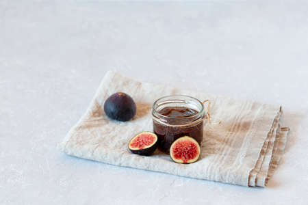 organic fig homemade confiture made by family recipe in a small jar on gray concrete background, side view, copy spaceの写真素材