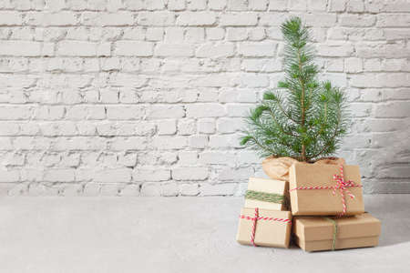 small New Year tree with Christmas gift boxes on the brick wall background, zero waste conceptの写真素材