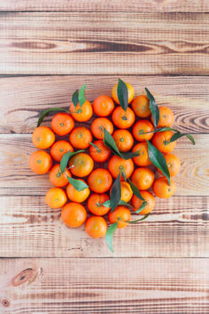bright mandarines in the middle of wooden background, flatlay
