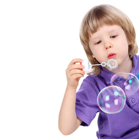 closeup image of the handsome little boy blowing the big soap bubblesの写真素材