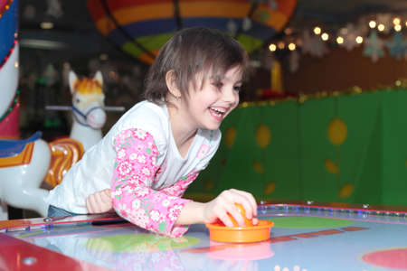 cute little girl playing air hockeyの写真素材
