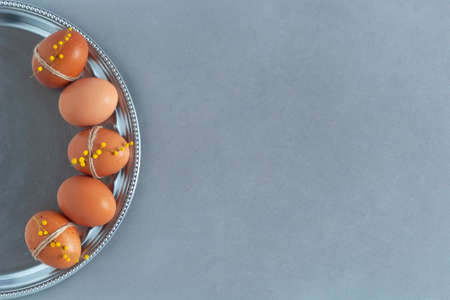 colorful chicken eggs on a silver round plate, easter concept, gray background, top view, copy space,の写真素材