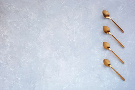 gray background with golden coffee spoons, top view, space for creating a list, plan, scheduleの写真素材