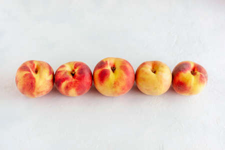 red and yellow peaches in a row, top viewの写真素材