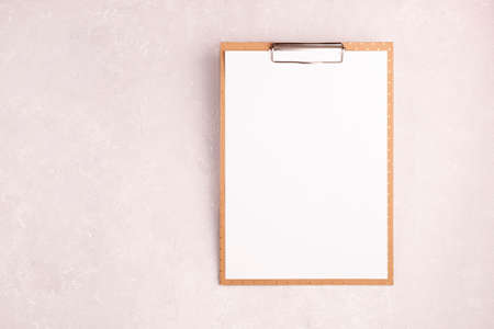 marron clipboard with a blank sheet of paper on he light pink background, mock-up, copyspaceの写真素材