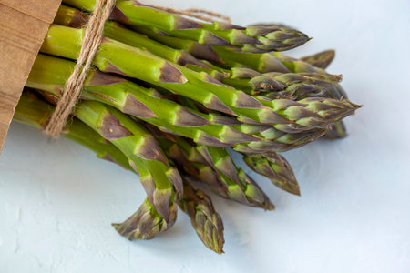 bunch of fresh organic. asparagus diagonal on the light blue background, top viewの写真素材