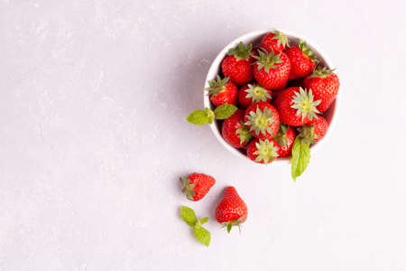 white round bowl full of big bright strawberries, gray concrete background, top view, copyspaceの写真素材